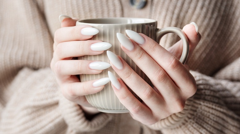 woman holding cup with nails