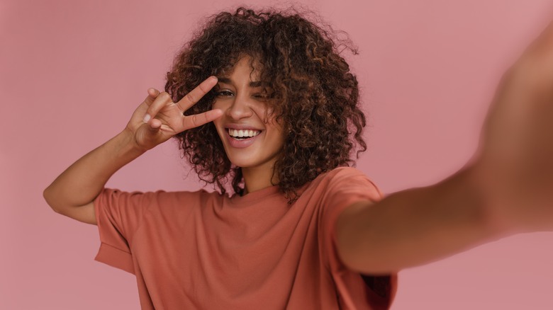 curly haired woman taking selfie