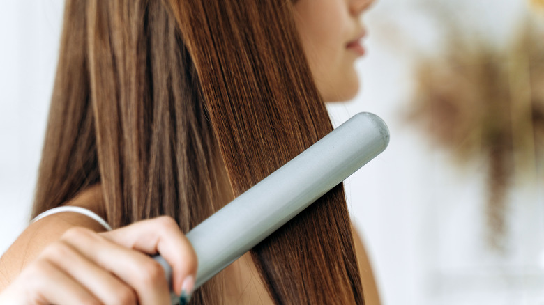 woman using flat iron