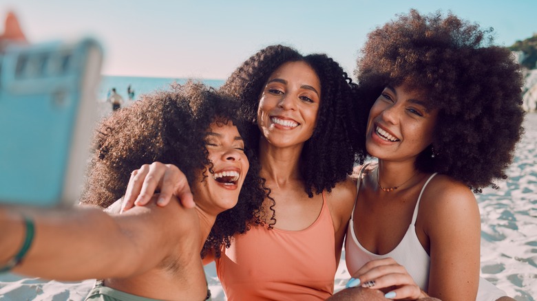 Three women taking beachfront selfie