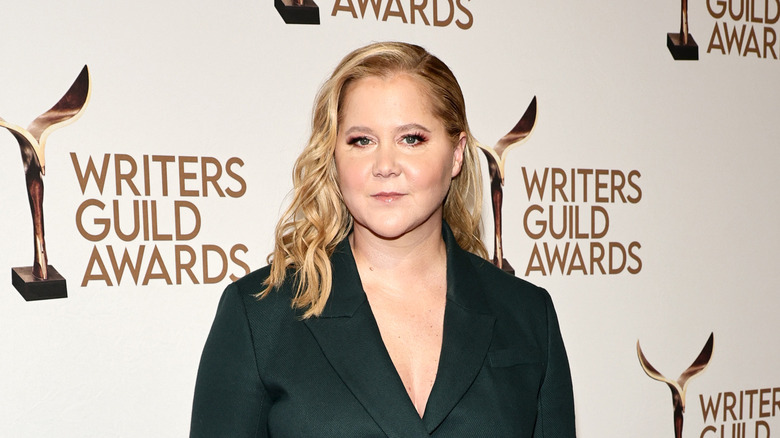 Amy Schumer in a dark green suit