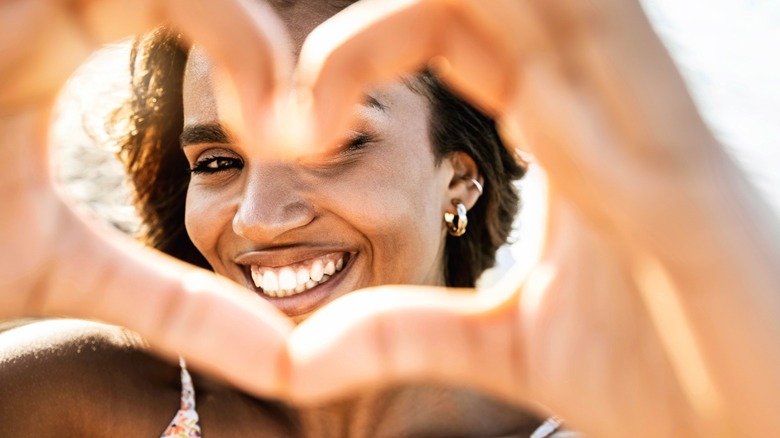 Woman holding up hands to make heart 