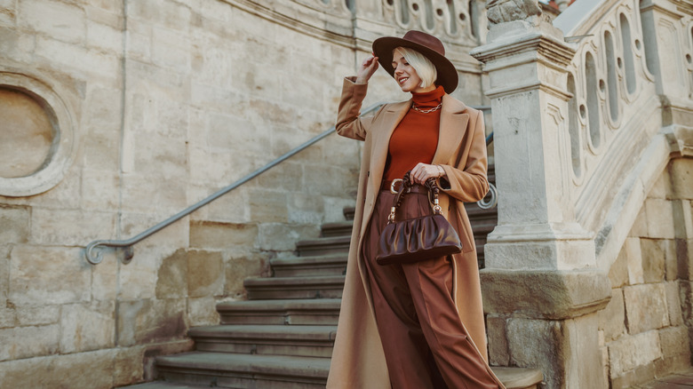 Woman in fedora hat and long camel coat