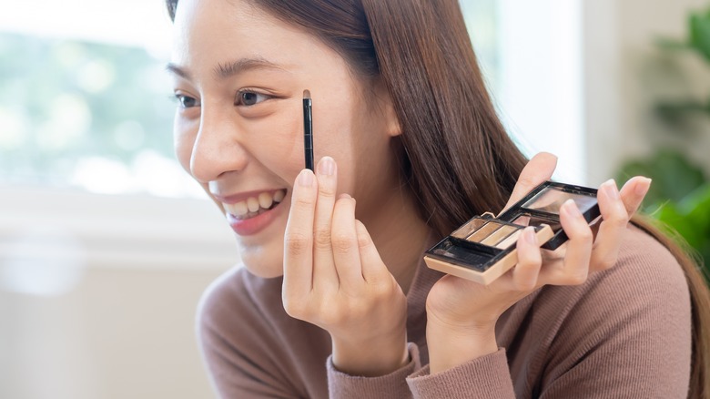 Woman putting on eyeshadow