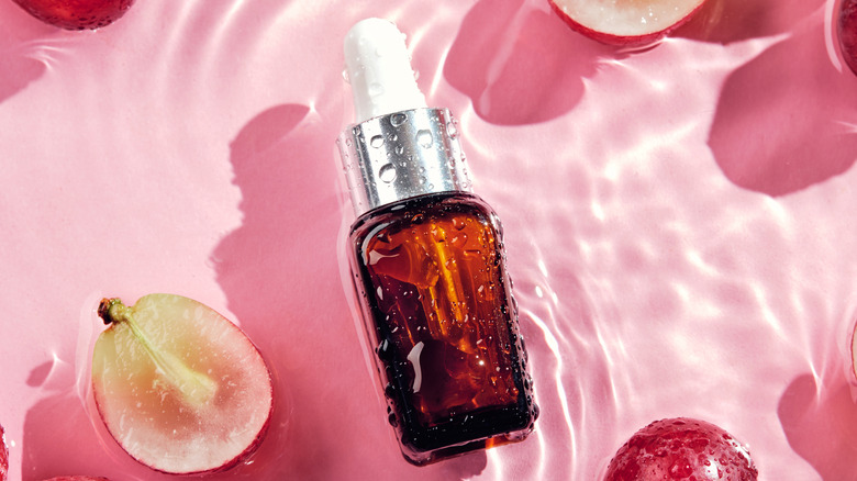 Skincare oil surrounded by fruit