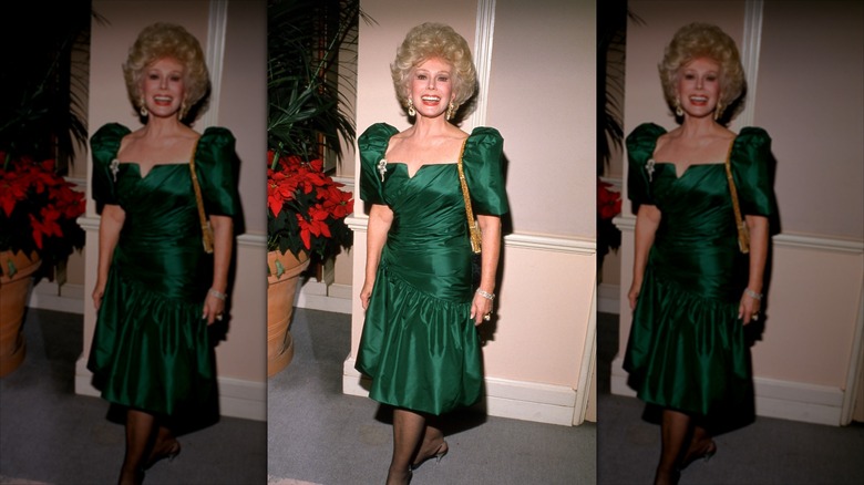 Eva Gabor smiles wearing an emerald green dress and voluminous hair.