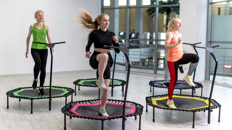 Three women jumping on mini trampolines