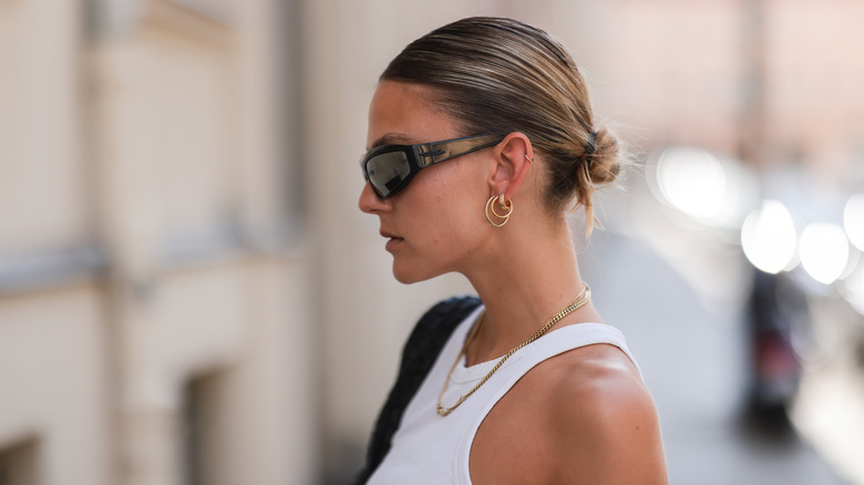 Woman standing outside with a hair bun