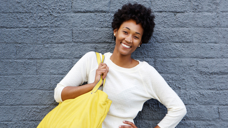 Smiling model carrying handbag