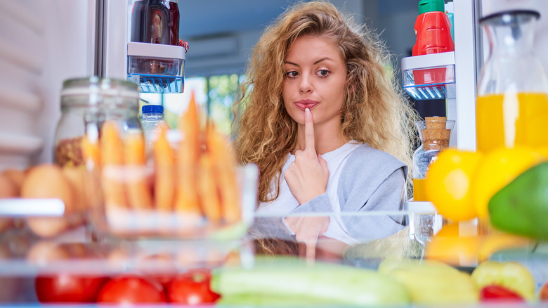 woman looking inside fridge 