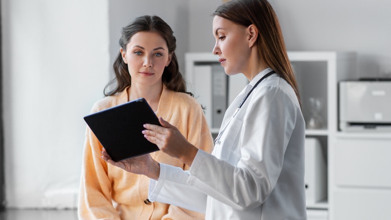 Doctor shows tablet to patient