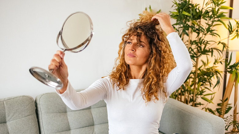 Girl with curly hair holding mirror