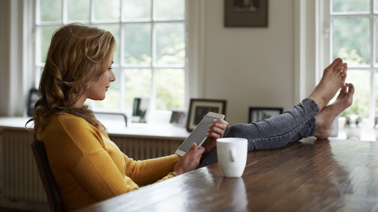 Woman reading tablet at home