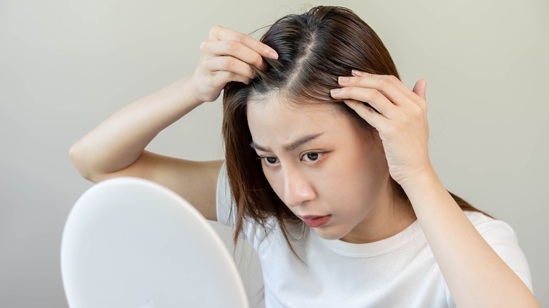 Woman looking at her scalp.