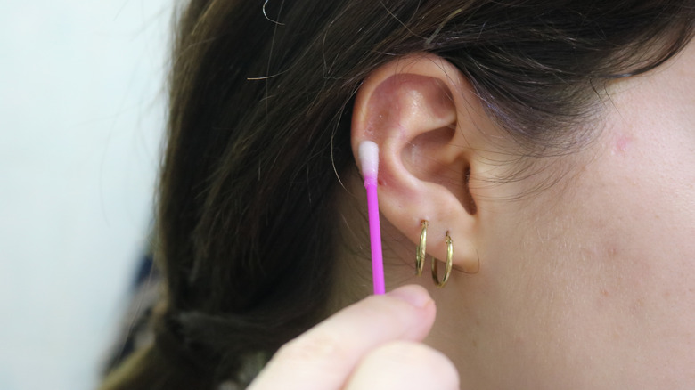 Woman clean ear piercings 