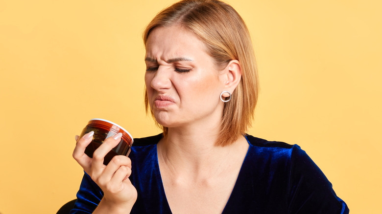 Woman sniffing an expired product