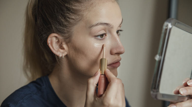 woman applying concealer