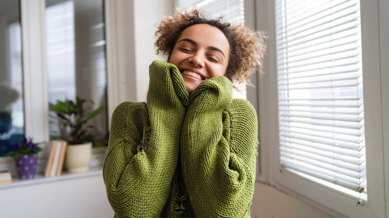 woman smiling and touching face