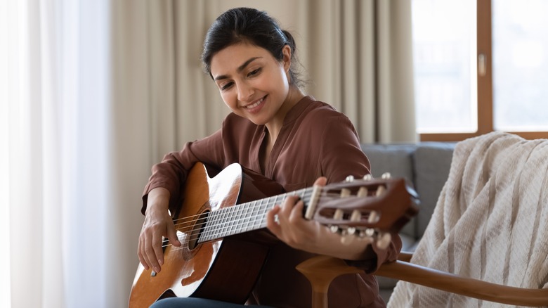 person playing guitar at home