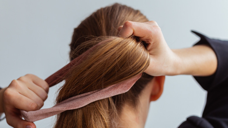 Woman tying a ponytail