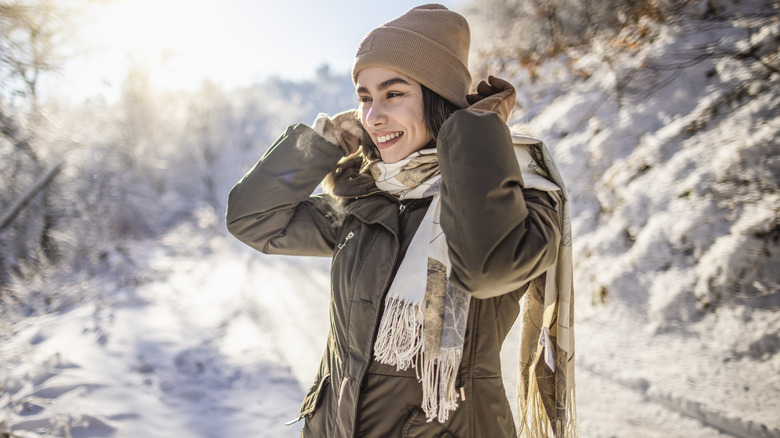 Woman wearing coat and hat snowy background
