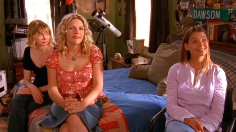 Michelle Williams, Busy Philips, and Katie Holmes sit in Dawson Leery's room in an episode of 