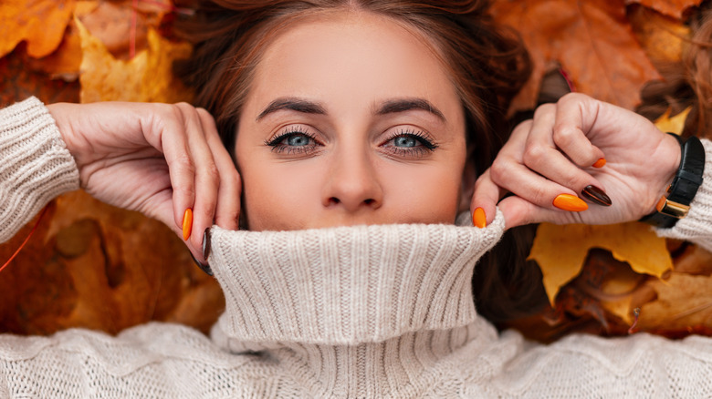 woman covering lips with sweater