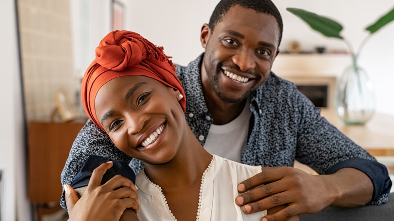 smiling couple hugging at home