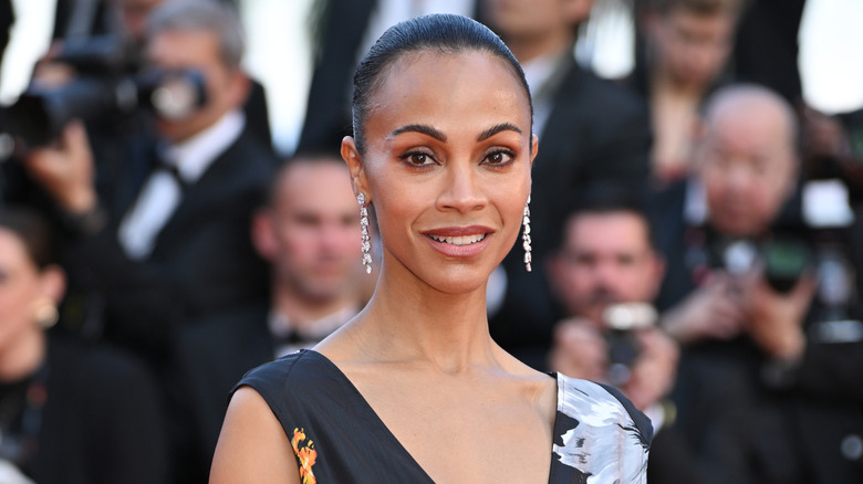 Zoe Saldana in a black floral dress with her hair in a slicked bun