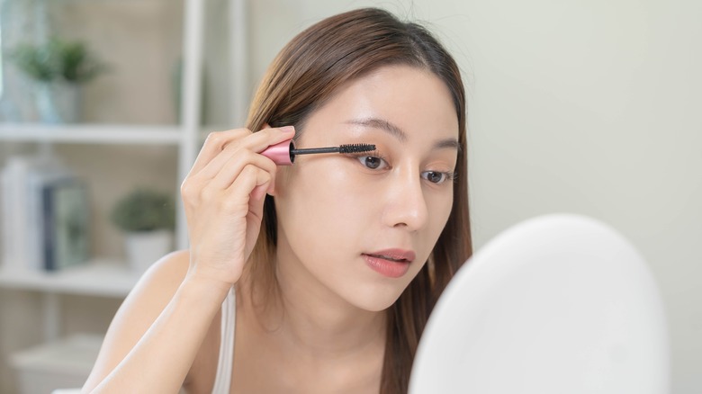 woman applying mascara to lashes