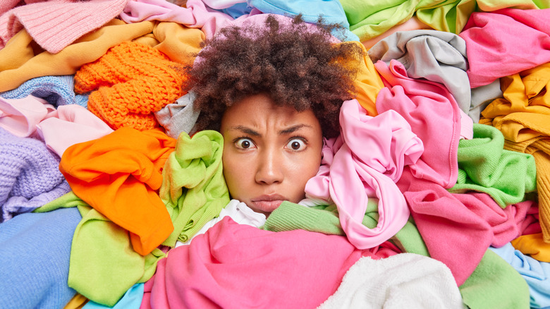 stressed African American woman surrounded by clothes