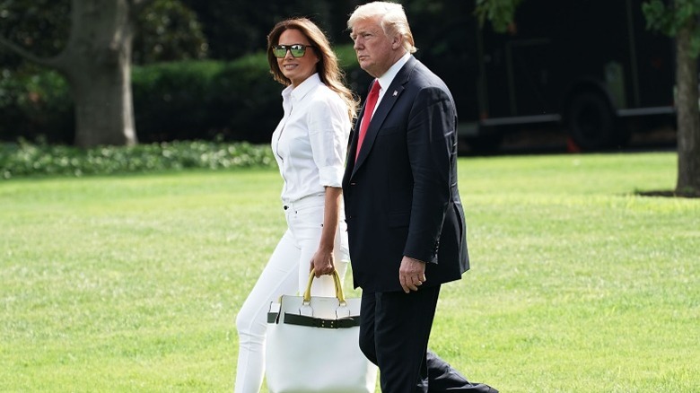Melania and Donald Trump walk across the White House lawn