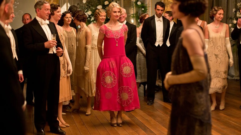 Lily James as Lady Rose wearing a bright pink drop waist dress with floral embellishments