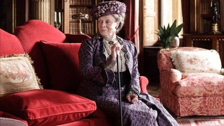 Maggie Smith as Violet Crawley wearing a purple Victorian-era style outfit on Downton Abbey