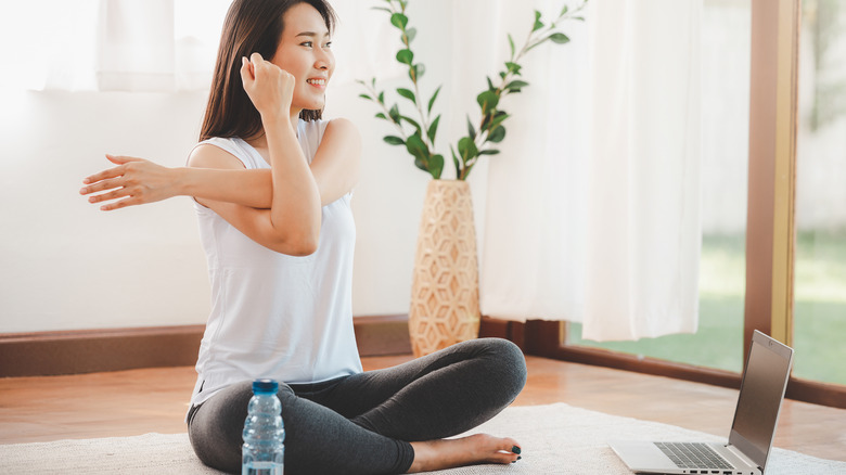 woman stretching with weights and computer