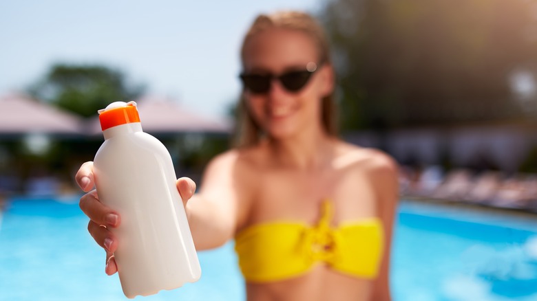 woman holding sunscreen 