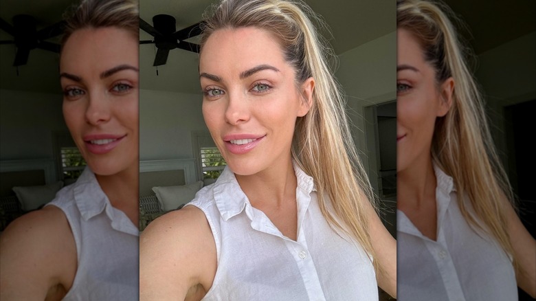 Crystal Hefner smiles in a white tank top