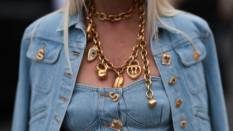 person wearing chunky necklacesc with charms
