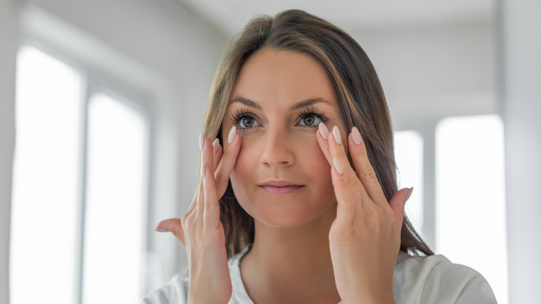 Woman rubbing underneath eyes