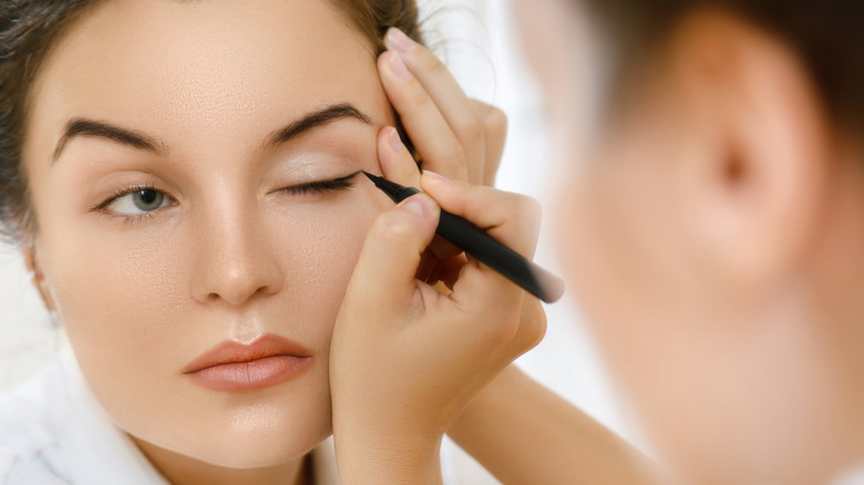 woman applying eyeliner