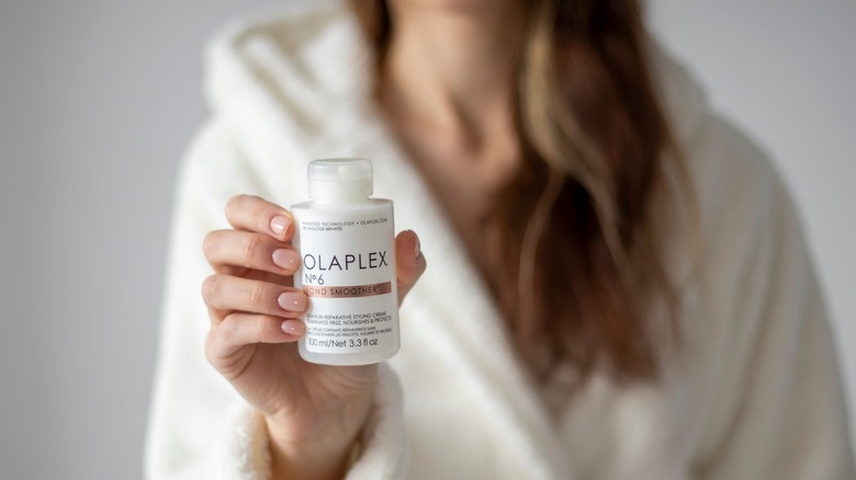 Woman holding Olaplex shampoo