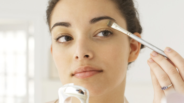 female doing eye makeup