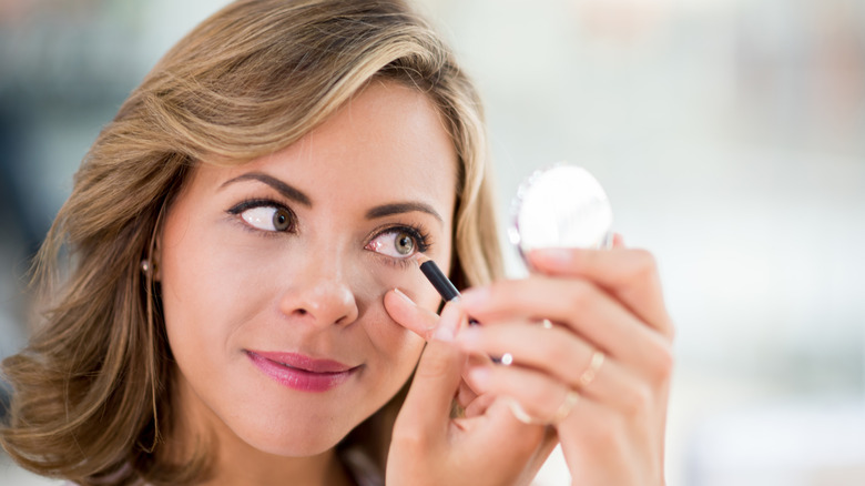 Woman applying eyeliner