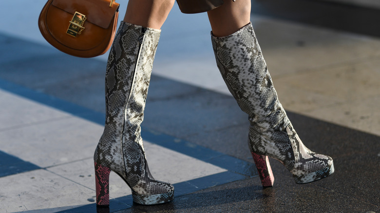 Close up of knee-high boots walking in the city