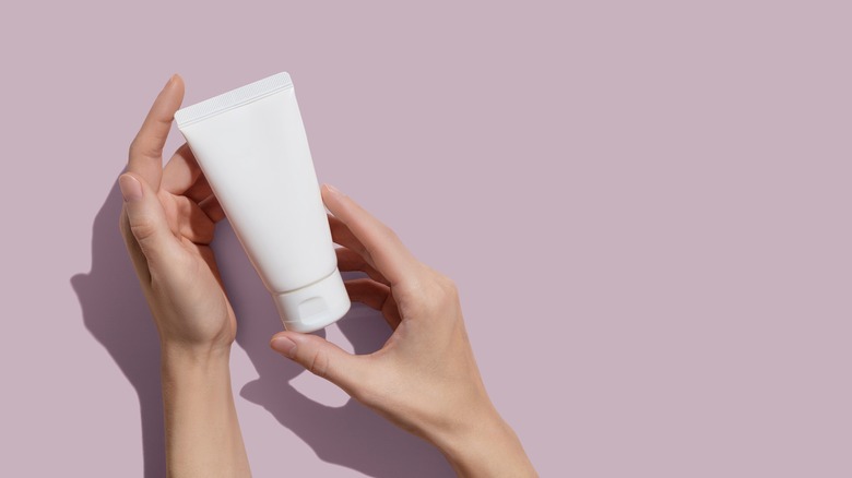 person holding tube of product