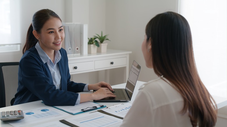 Two women sit at desk for job interview 