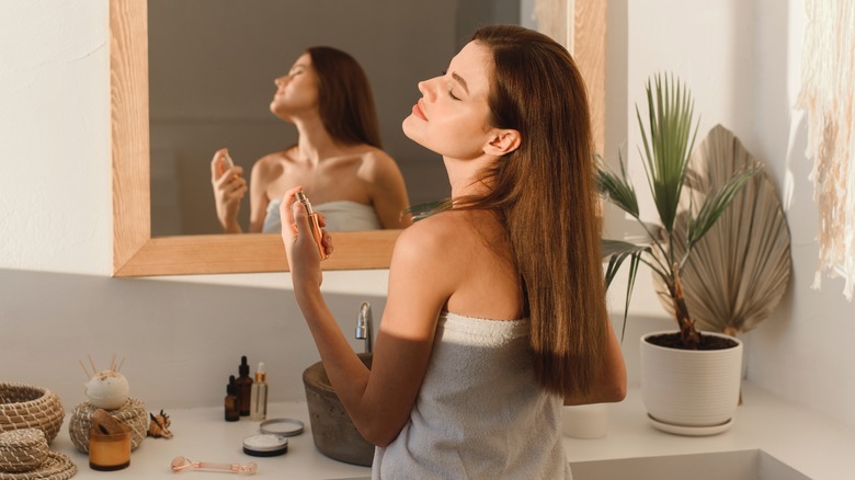 Woman spritzing perfume on herself