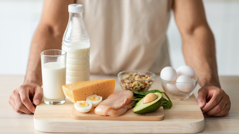 man standing in front of proteins, vegetables and dairy products