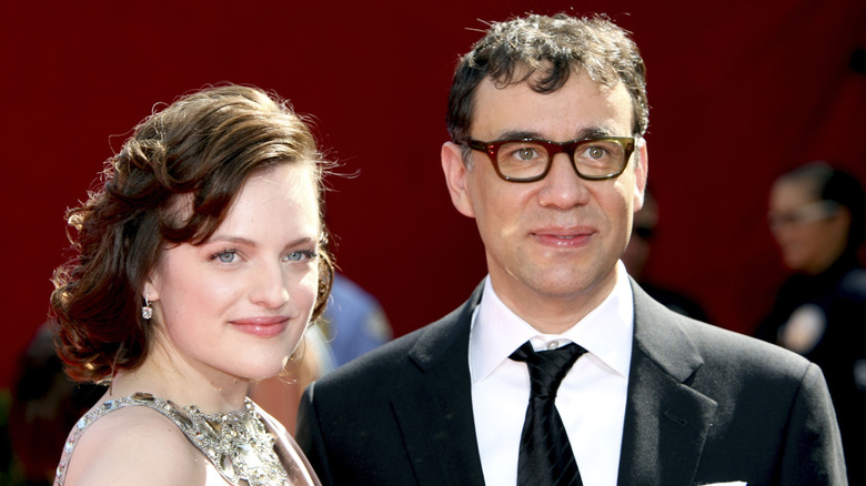 Elisabeth Moss and Fred Armisen look on while being photographed together at a red carpet event