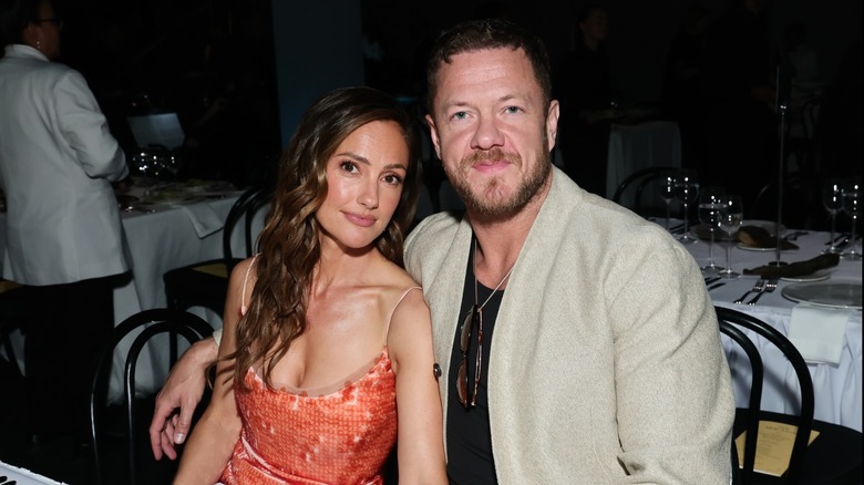 Minka Kelly and Dan Reynolds pose for a photo while sitting at a dining table together